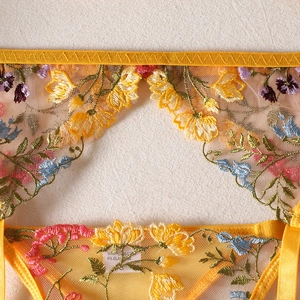 Detail shot of yellow floral embroidery and lace fabric on a sexy lingerie set