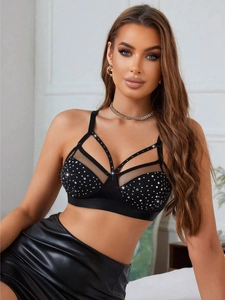 Détail du soutien-gorge en maille noire avec strass brillants et bretelles ajourées