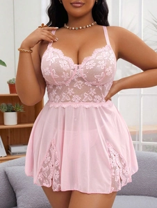 Detail of floral lace cups and sheer mesh fabric on a light pink babydoll nightgown
