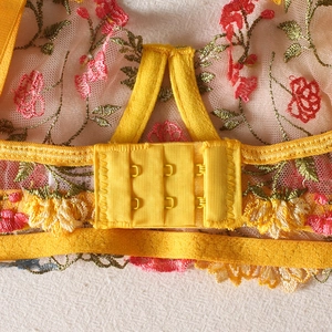 Detailed back view of yellow floral lace bra with double hook-and-eye closure and embroidery
