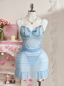 Dettaglio sottoveste in tulle azzurro con ricami floreali e spalline di perle