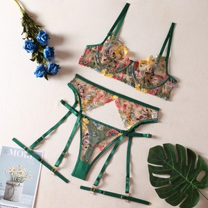 Detail of floral embroidery on sheer mesh lingerie with adjustable garter belt straps