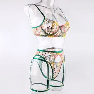 Detail of floral embroidery on sheer mesh lingerie set with forest green straps