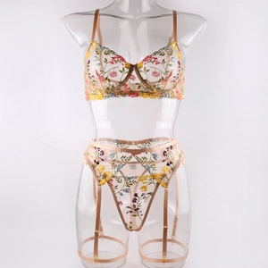 Detail of floral embroidery on sheer mesh lingerie set with garter belt and metal buckles
