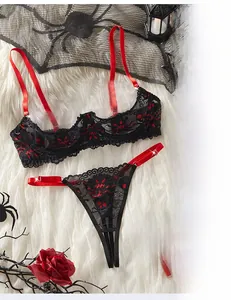 Détail d'un ensemble de lingerie en dentelle rouge et noire sur un tapis en peluche
