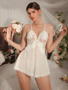 Close-up of white bridal nightdress with intricate floral lace and sheer mesh details