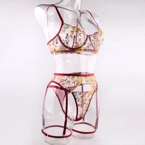 Detail of floral embroidery on sheer mesh lingerie set with garter straps and leg rings