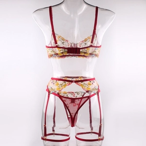 Detail view of red sheer mesh lingerie back with yellow floral embroidery and garters