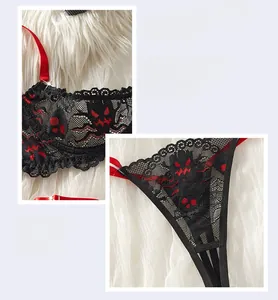 Détail de lingerie en dentelle noire avec broderie diable rouge et rubans de soie