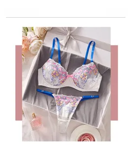 Détails de l'ensemble de lingerie blanche avec broderies florales et bretelles bleues