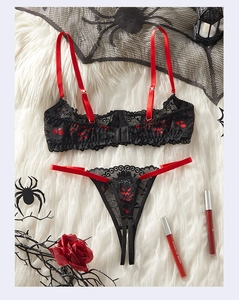 Détail d'un ensemble de lingerie en dentelle rouge et noir avec motifs d'Halloween