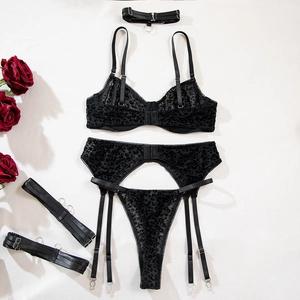Detailed flat lay of black leopard print lace lingerie set with red rose decor