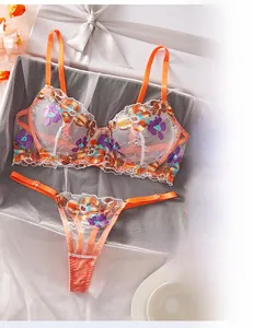 Detailed embroidery view of orange mesh bra and thong set in luxury gift box
