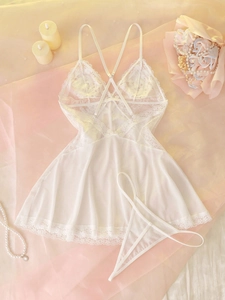 Flat lay of white lace nightdress set with mesh hem and pearl decor in romantic setting