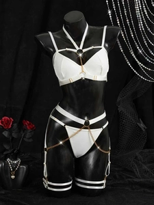 Détail de l'ensemble de lingerie blanche avec chaînes et anneaux en métal doré sur un mannequin