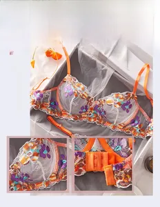 Detail showing colorful floral embroidery on sheer mesh orange bra with adjustable straps