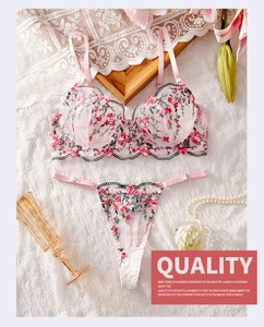 Détail de la broderie florale rose sur l'ensemble de lingerie en dentelle et tulle