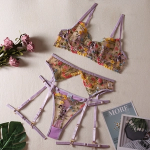 Detailed embroidery on lavender lace lingerie set with floral patterns and gold adjusters
