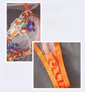 Detail view of orange mesh lingerie set with intricate floral embroidery and white lace