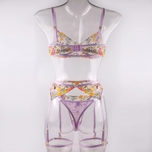 Detail of floral embroidery on sheer mesh lingerie with garters and adjustable leg straps