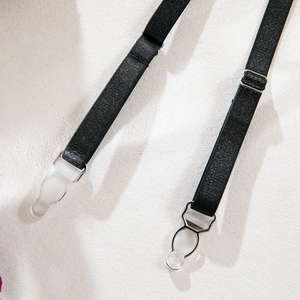 Detail of black glitter elastic garter straps with silver metal buckles and clear clips