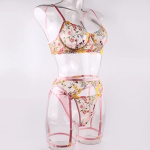 Detailed embroidery of floral lace on sheer pink lingerie with garter belt set
