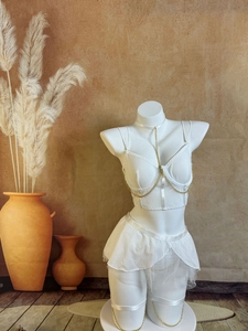 Détail de l'ensemble de lingerie en tulle blanc avec chaînes dorées sur un mannequin