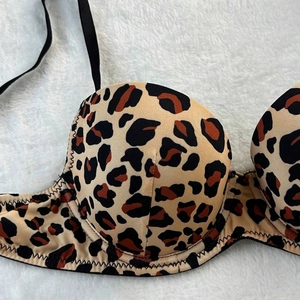Detail of leopard print lingerie top featuring black zigzag stitching and thin straps
