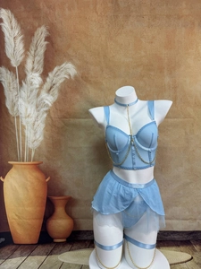 Détail d'un ensemble babydoll bleu clair avec tulle et chaînes dorées décoratives sur un mannequin