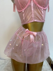 Detail eines rosa Netz-Lingerie-Sets mit Laser-Herzmustern und Satinschleife am Rock