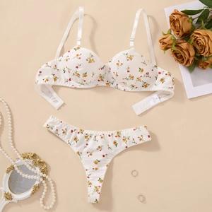 Detailed close-up of white floral bra set with orange flower print and size S label