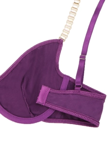 Vue macro d'un soutien-gorge en satin violet avec chaîne dorée et coutures fines