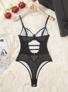 Flat lay of sheer black mesh leopard bodysuit with cutout lace-up back and rose props