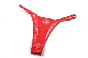 Détail d'un string en dentelle rouge avec lanières réglables et tissu satiné