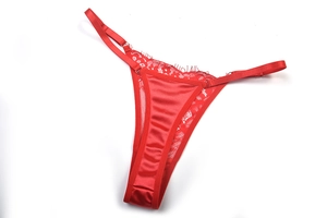 Détail de string en dentelle rouge avec lanières en satin et boucles en métal réglables