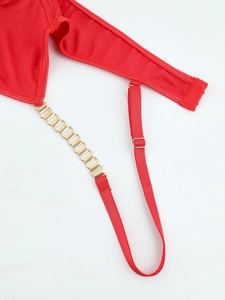 Détail de la bretelle rouge avec maillons de chaîne dorés et boucle de réglage
