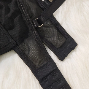 Detail of sexy black mesh bodysuit featuring triple hook-and-eye back closure and straps