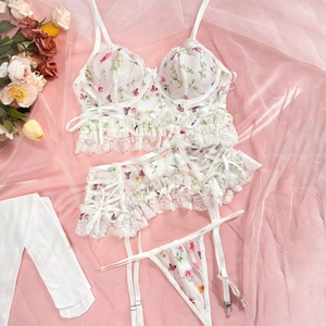 White floral mesh lingerie set with lace embroidery and matching stockings on silk