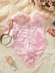 Détail à plat d'un body lapin en satin rose avec laçage et bordure en fourrure