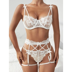 Completo intimo tre pezzi in pizzo bianco con reggicalze e fiocchi, vista frontale elegante