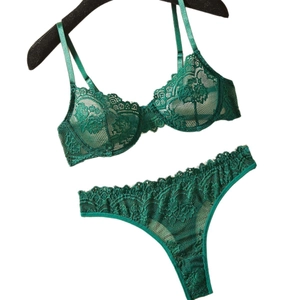 Elegant emerald green lace lingerie set with underwire bra and matching thong on a hanger