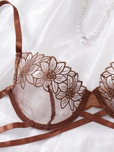 Detail of sunflower embroidery on brown mesh bra with elegant cross-strap design