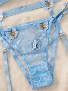 Détail de la culotte en dentelle bleue avec broderie papillon 3D et bretelles réglables