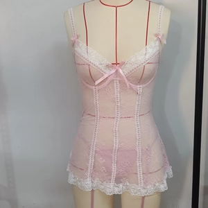 Dettaglio di lingerie in pizzo rosa con bordi floreali bianchi e fiocchi di raso