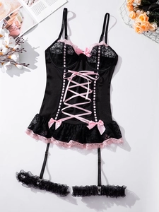 Detailed flat lay of a black corset bodysuit with pink lace trim and ribbon bow accents