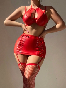 Détail d'un ensemble de lingerie en simili cuir rouge avec jupe à lacets et bas résille