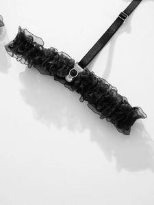 Detail of black ruffled mesh garter with adjustable strap and metal hook hardware