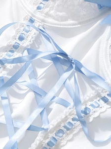 Detail of white lace bodysuit with light blue satin ribbon tie and wavy lace trim