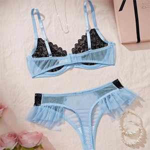 Détail d'un ensemble de lingerie en résille bleu clair et dentelle noire avec volants