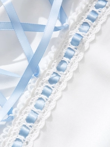 Detail of white lace trim with light blue satin ribbon and crisscross tie design